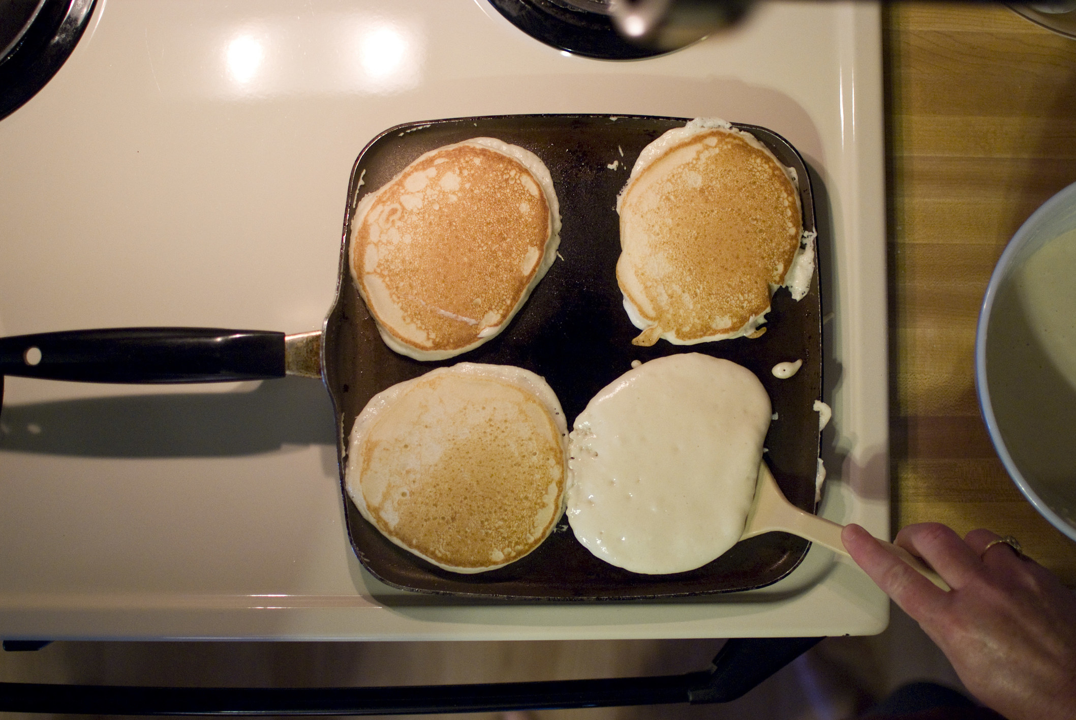 Pancakes cooking on a griddle.