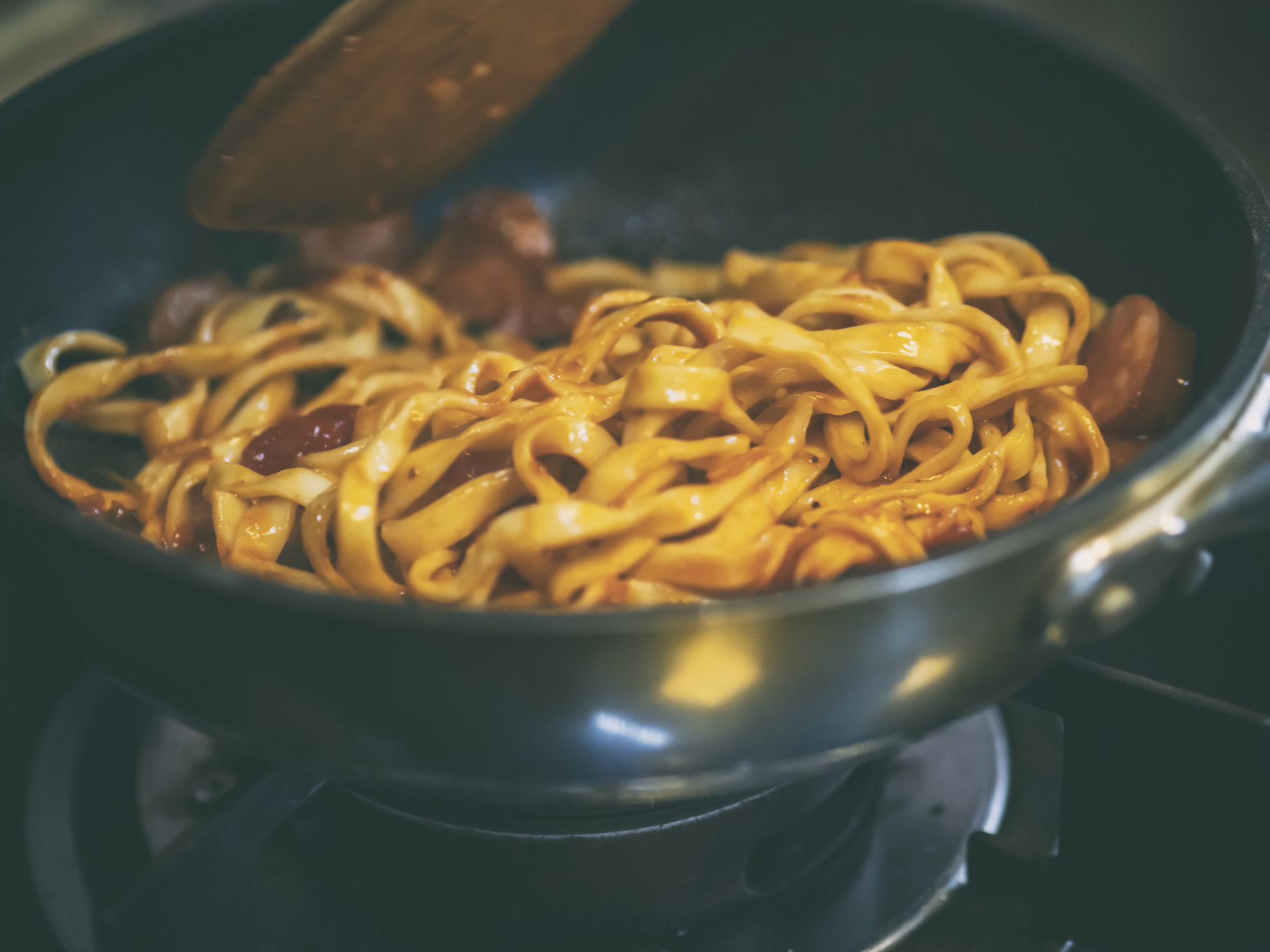 Stirring pasta in sauce.