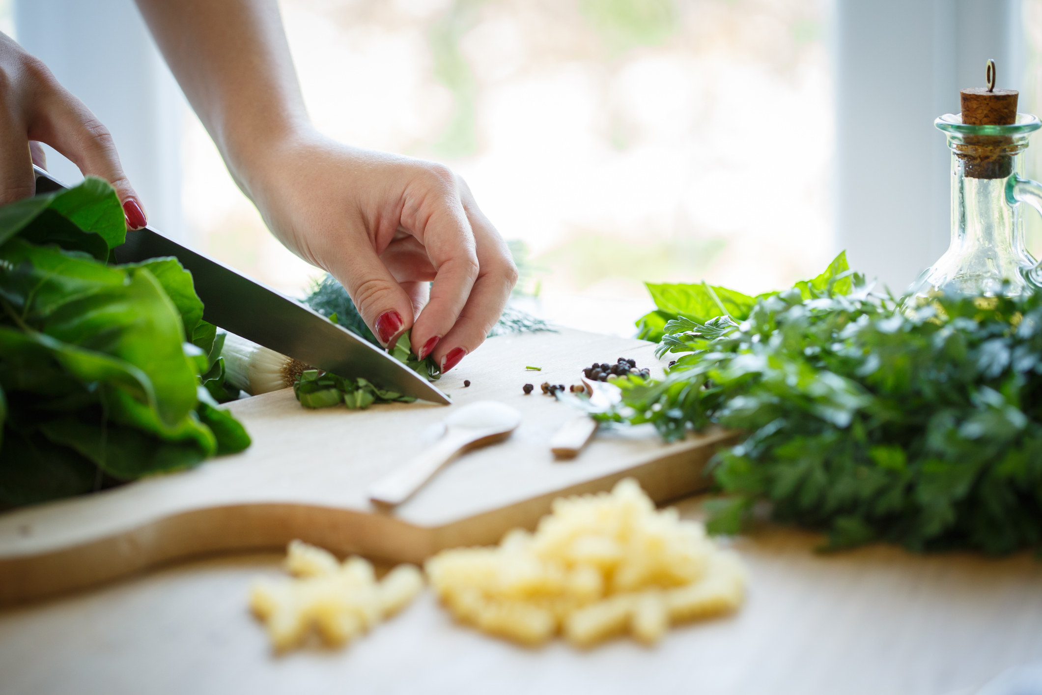 A person chopping fresh herbs.