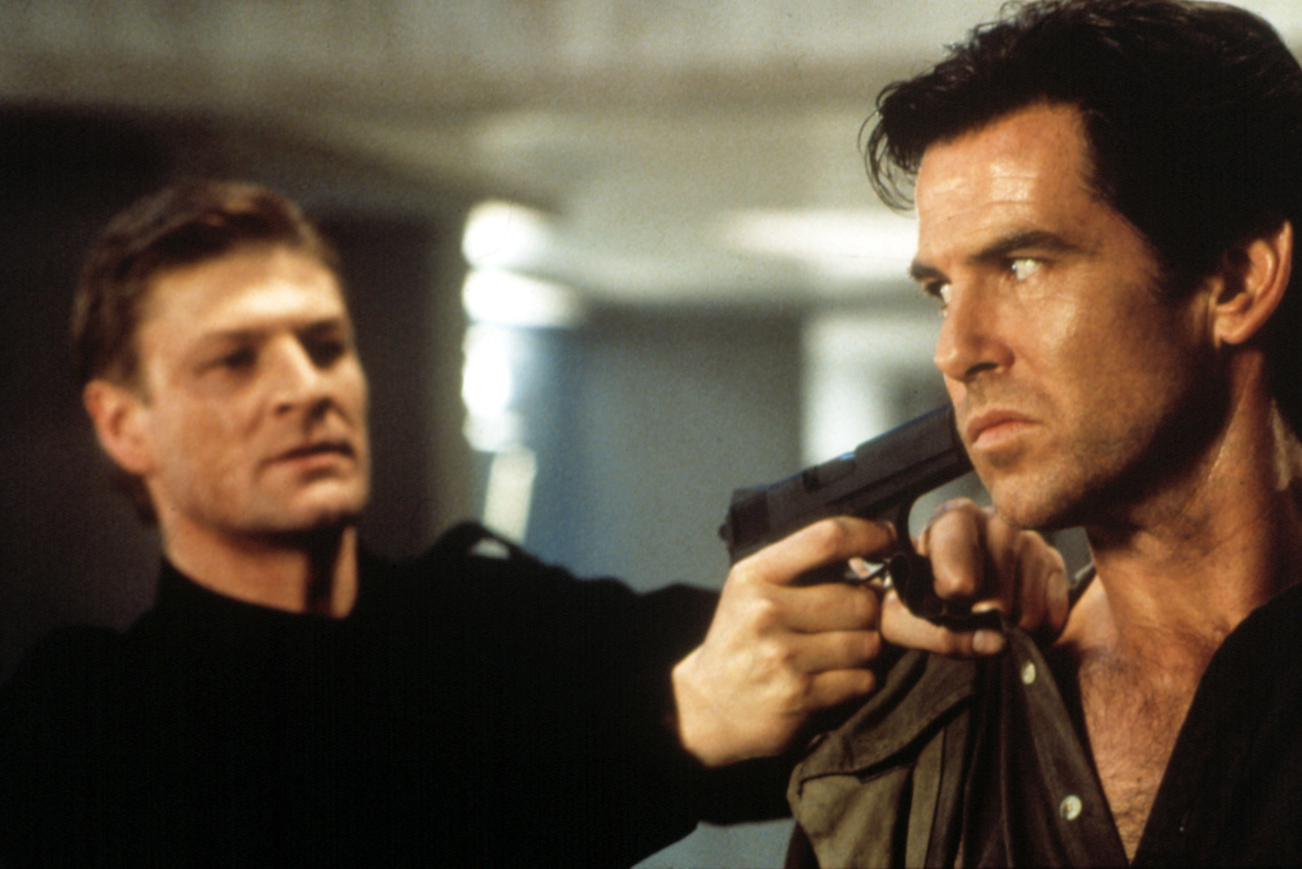 Sean Bean pointing a gun at Pierce Brosnan