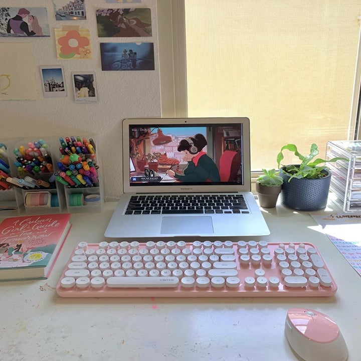 a pink keyboard and mouse in front of a laptop