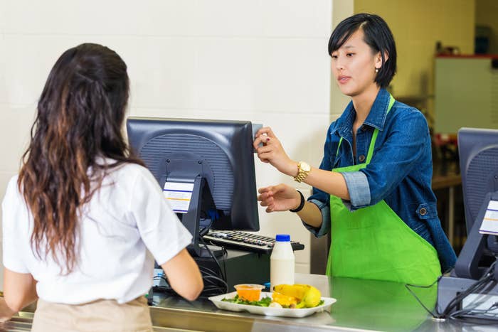 A girl paying for her lunch in a cafeteria