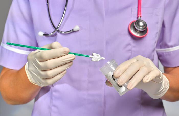 A doctor holding the scraping tool used for a pap smear