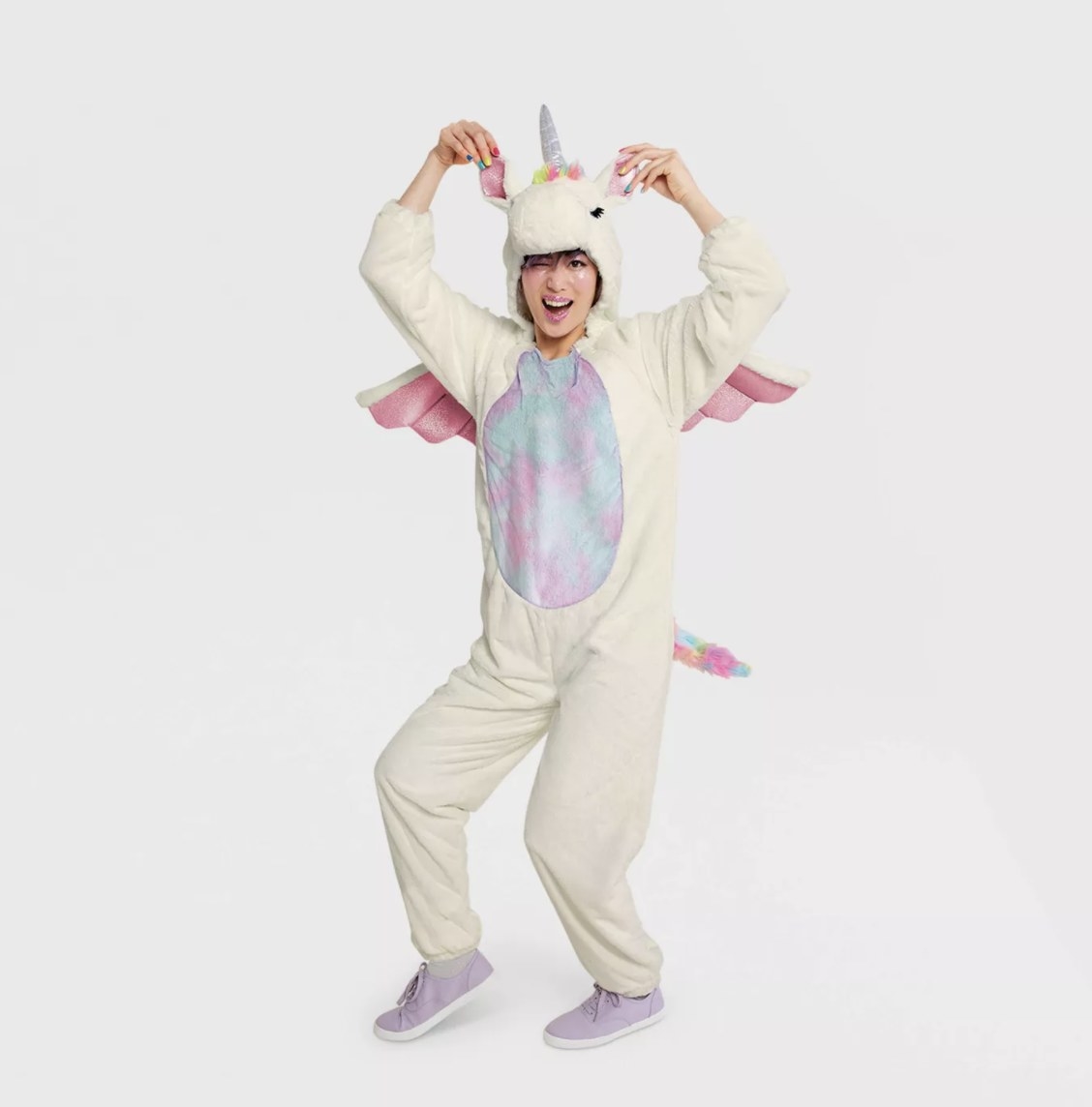 An adult is posing excitedly while wearing the soft plush white costume with silver, purple pink and blue shiny and cloudy accents