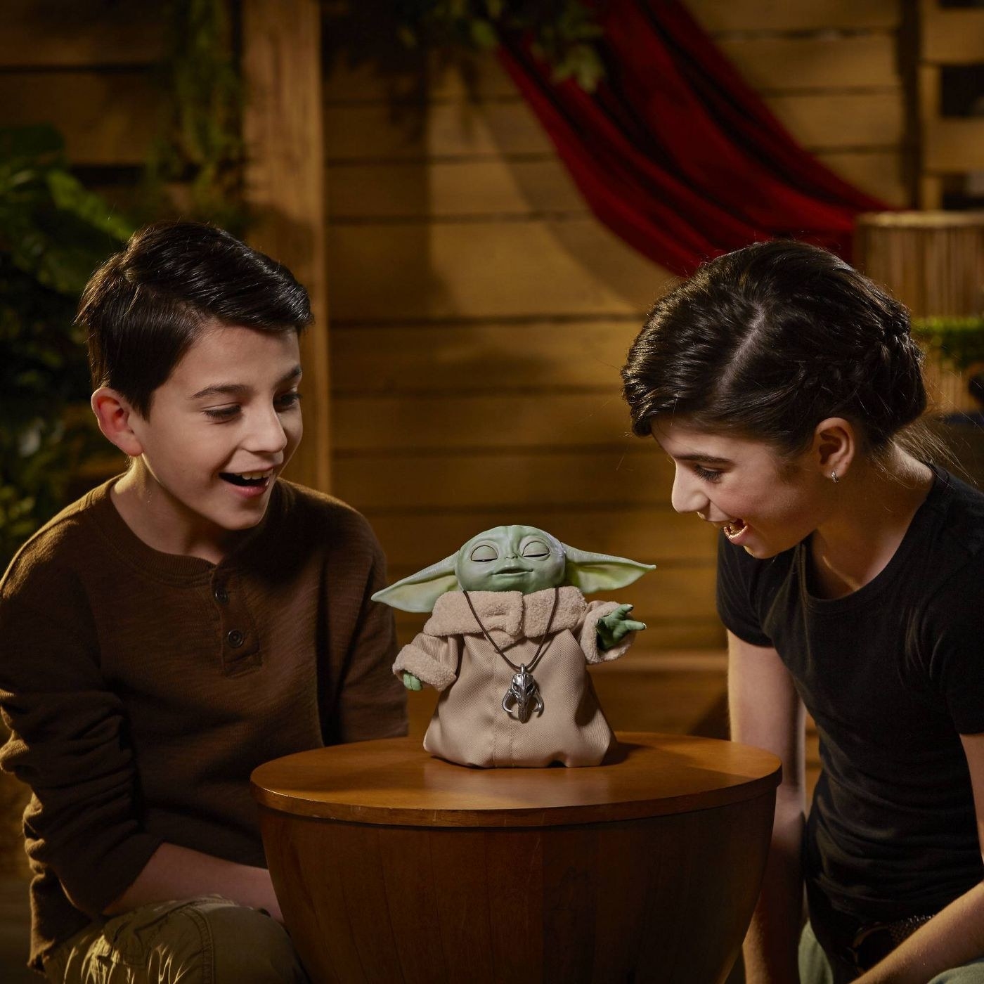 Two kids playing with a Baby Yoda doll