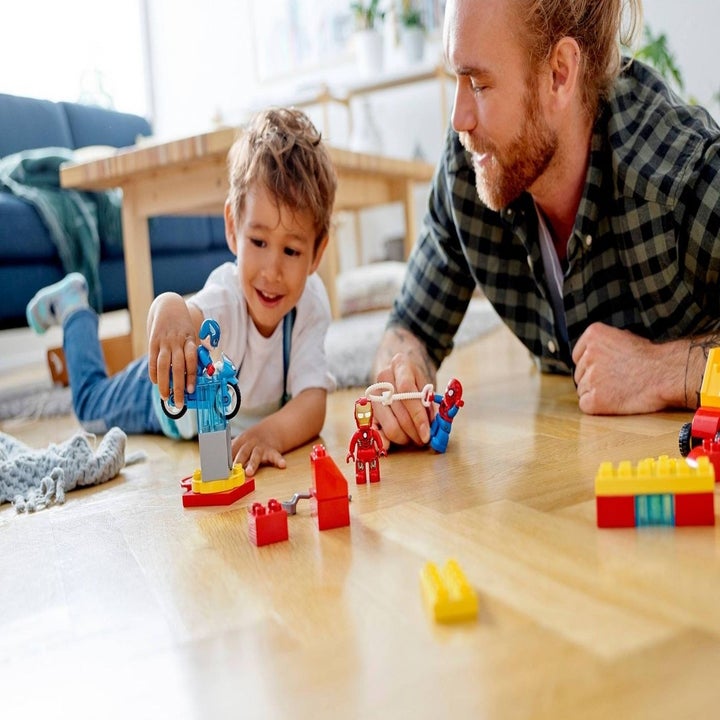 Kid and parent playing with Marvel lego set