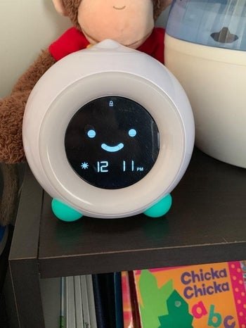 a reviewer photo of the clock and the digital face is happy with the eyes open like good morning
