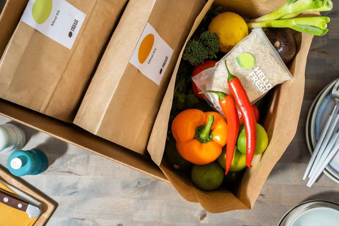 A top down shot of an opened HellloFresh delivery featuirng fresh produce and a meal kit.