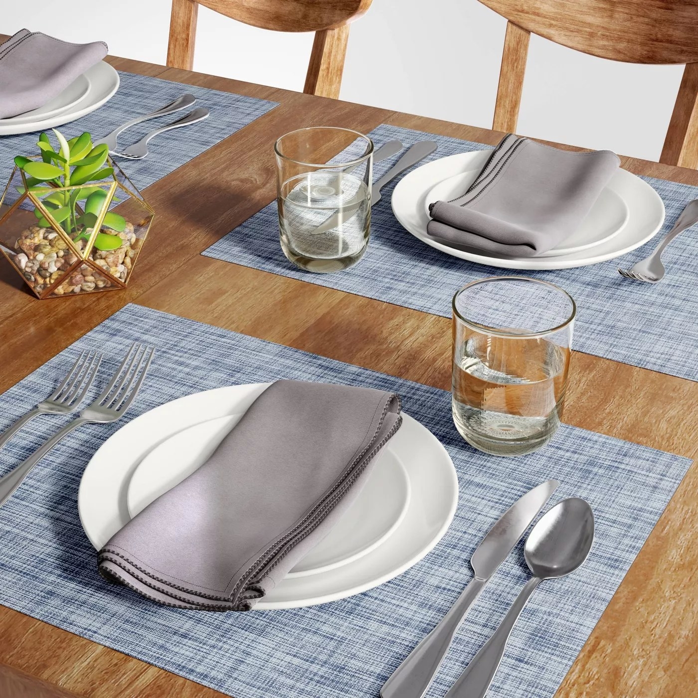 The blue placemats on a table underneath two place settings