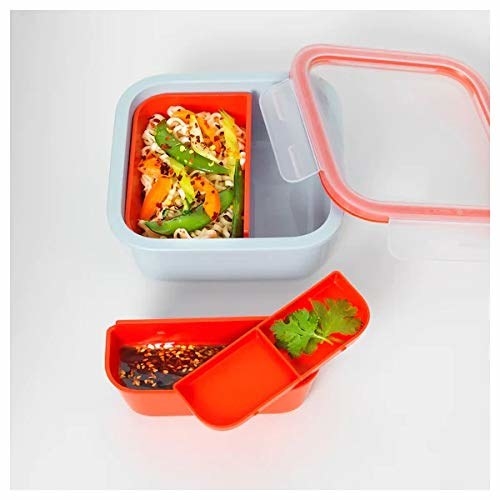 A red lunch box with food items in it