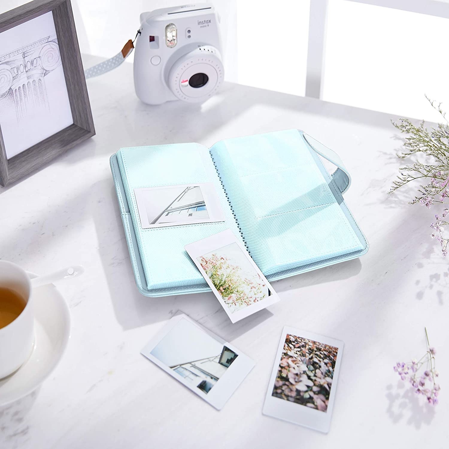 An album with instant photos on the table beside it