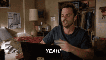 nick from new girl clapping his hands and saying &quot;yeah!&quot; in front of his laptop