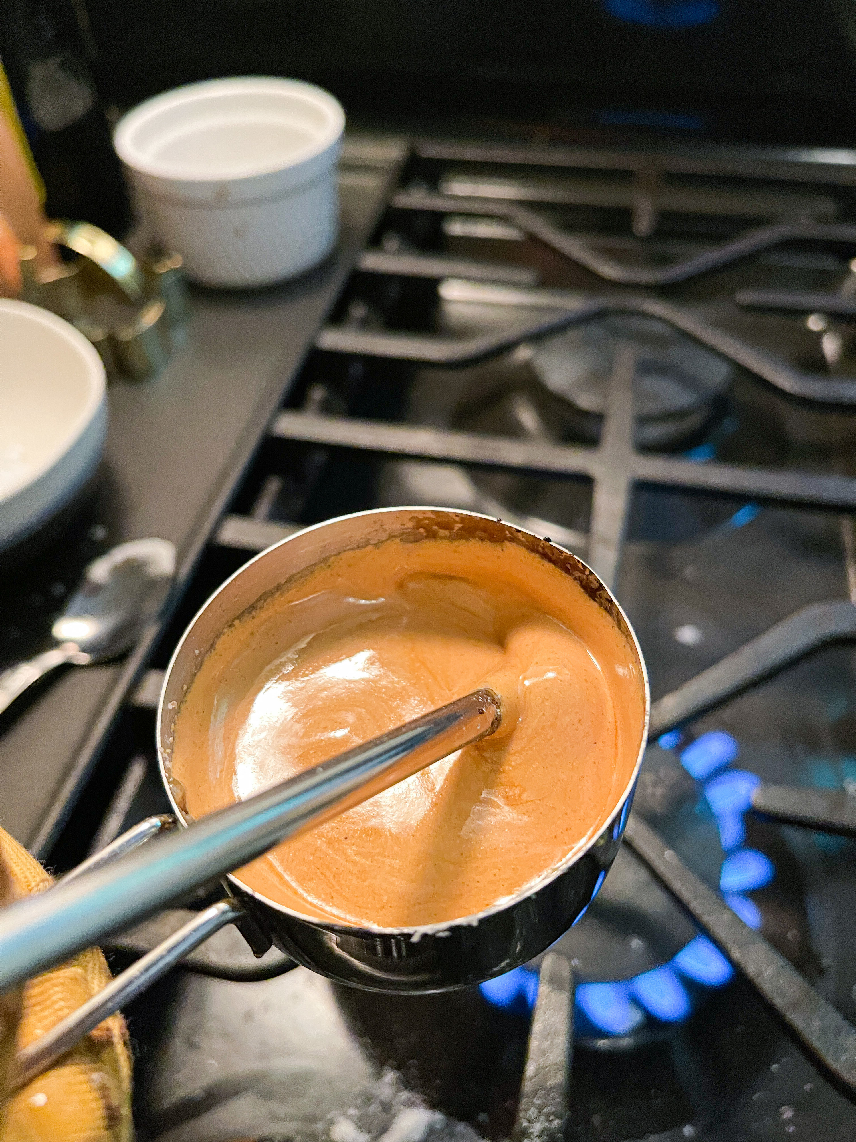 caramel in a measuring cup after baking soda is added to it; frothy and golden brown