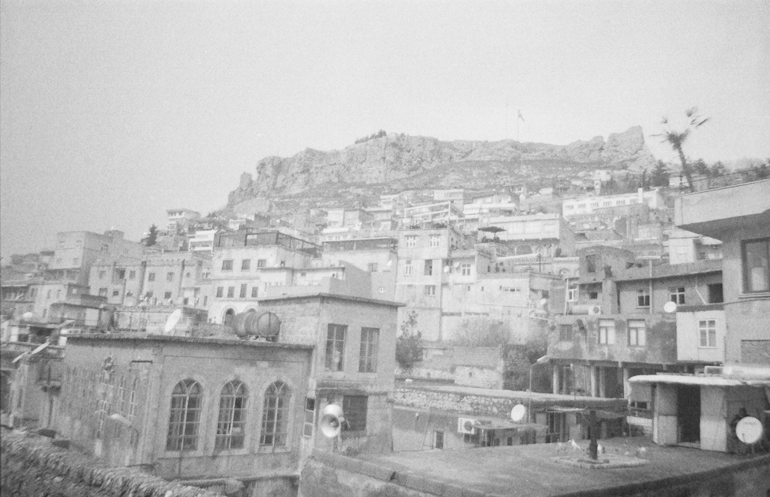 A cityscape in Reqqa, Syria, with houses built up on a hill 