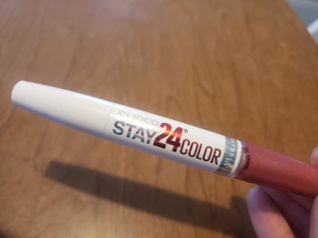Reviewer holding Super Stay 24 lipstick