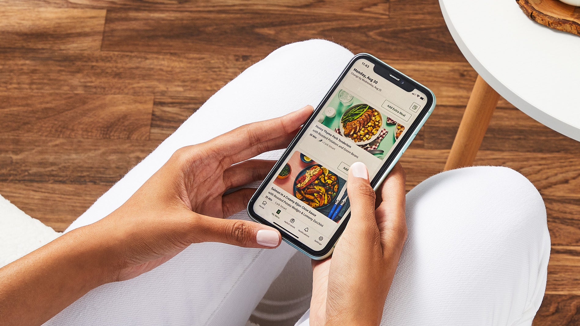 A person looks at HelloFresh menu options on their phone.