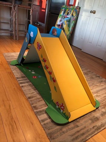 a review photo of the slide in a green yellow and blue color with animals and plants