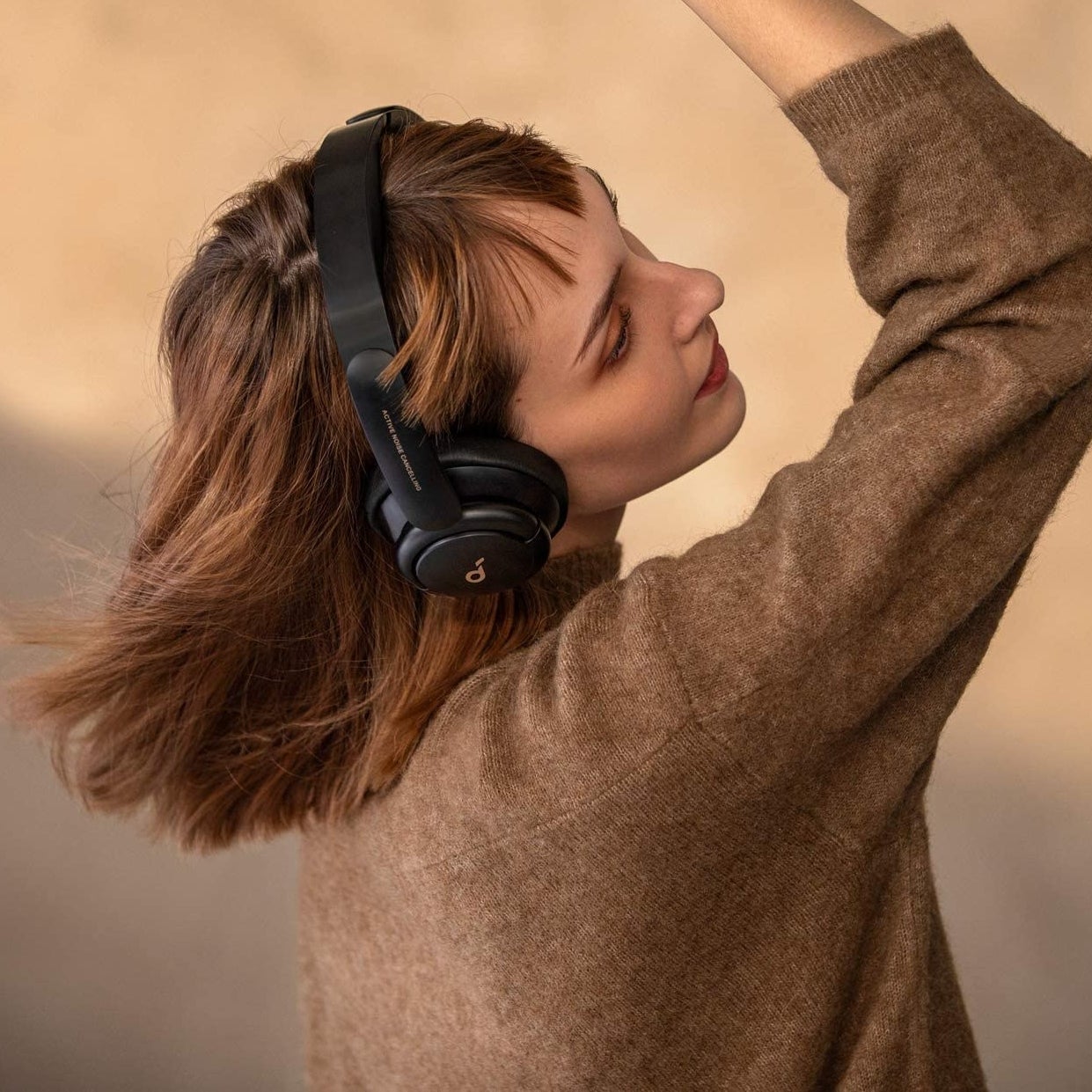 a person dancing while wearing the wireless over the ear headphones
