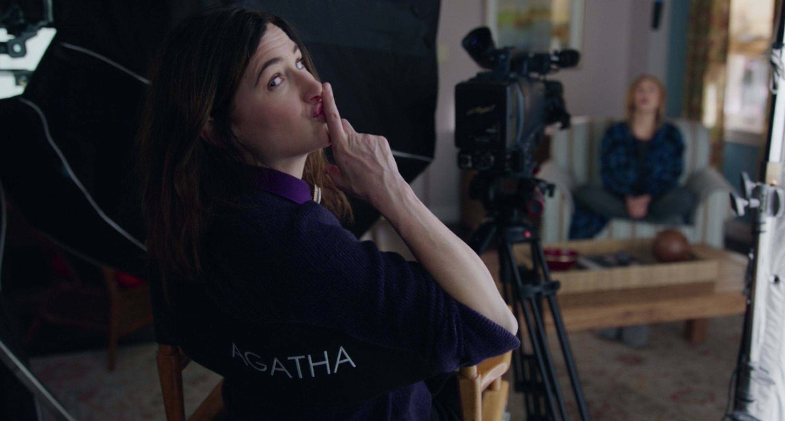 Agatha sitting in a director&#x27;s chair telling people to shush as Wanda does a confessional