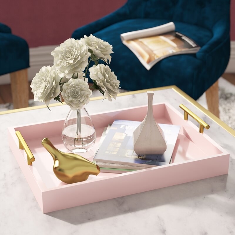 the pink tray with accessories on a clear table