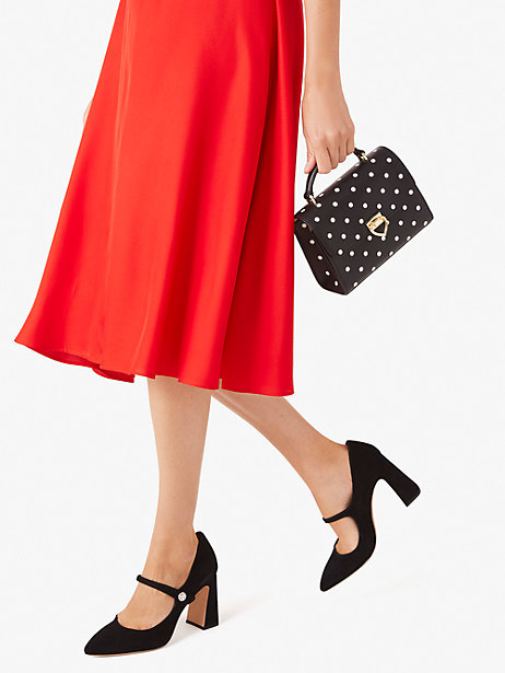 model carrying small black and white polka dot purse