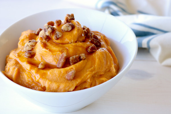 bowl of whipped yams topped with pecans