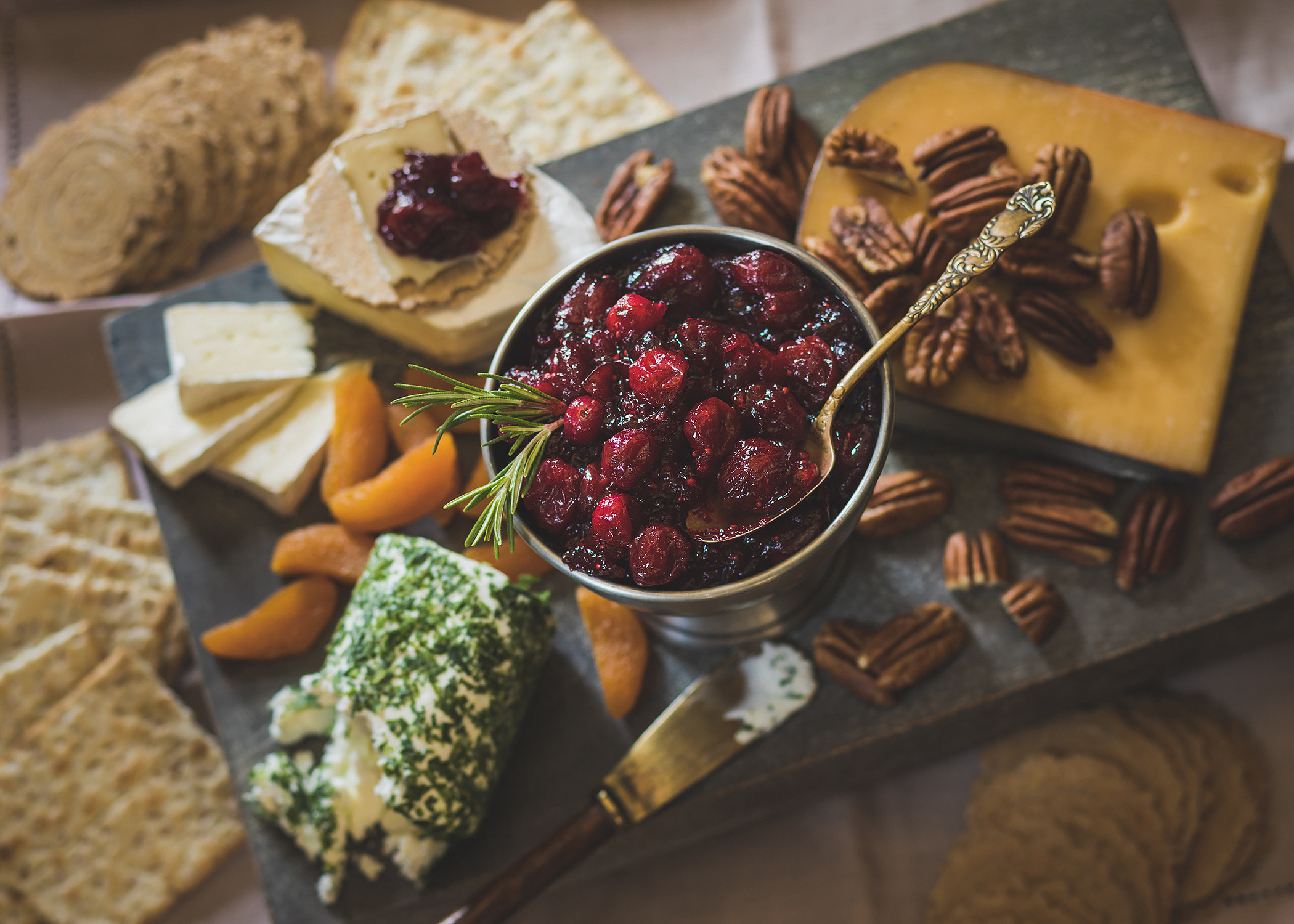 cheeseboard with small bowl of homemade cranberry sauce in the center