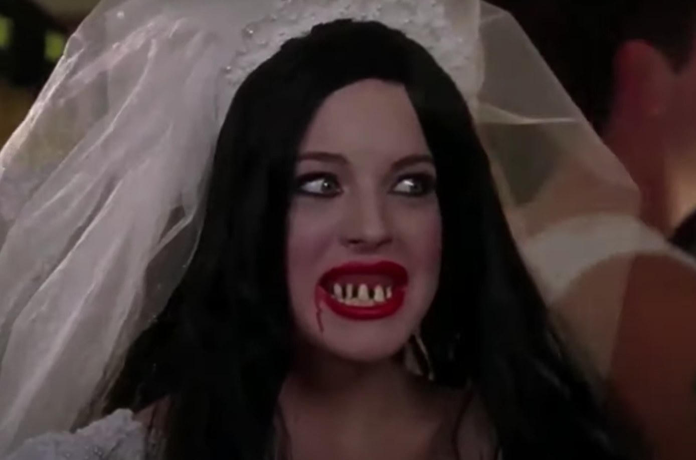 Cady wearing wedding gown covered in blood and veil with fake teeth and wig