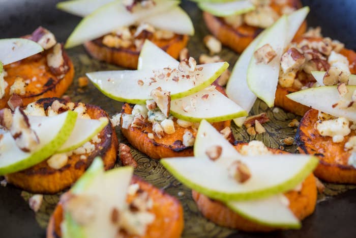 slices of sweet potato topped with pear slices and pecans