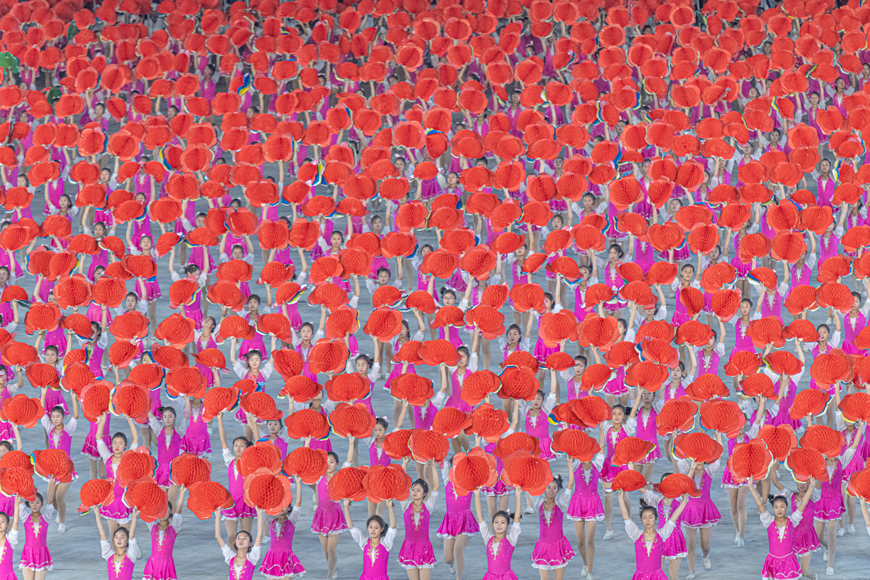 Many young North Koreans in colorful outfits participate in Arirang Mass Games, the largest performance of theater, artistry, gymnastics, and propaganda stories in the world