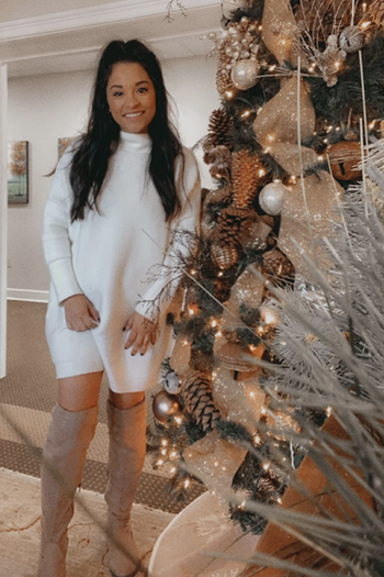 A customer review photo of them wearing the dress in white next to a Christmas Tree