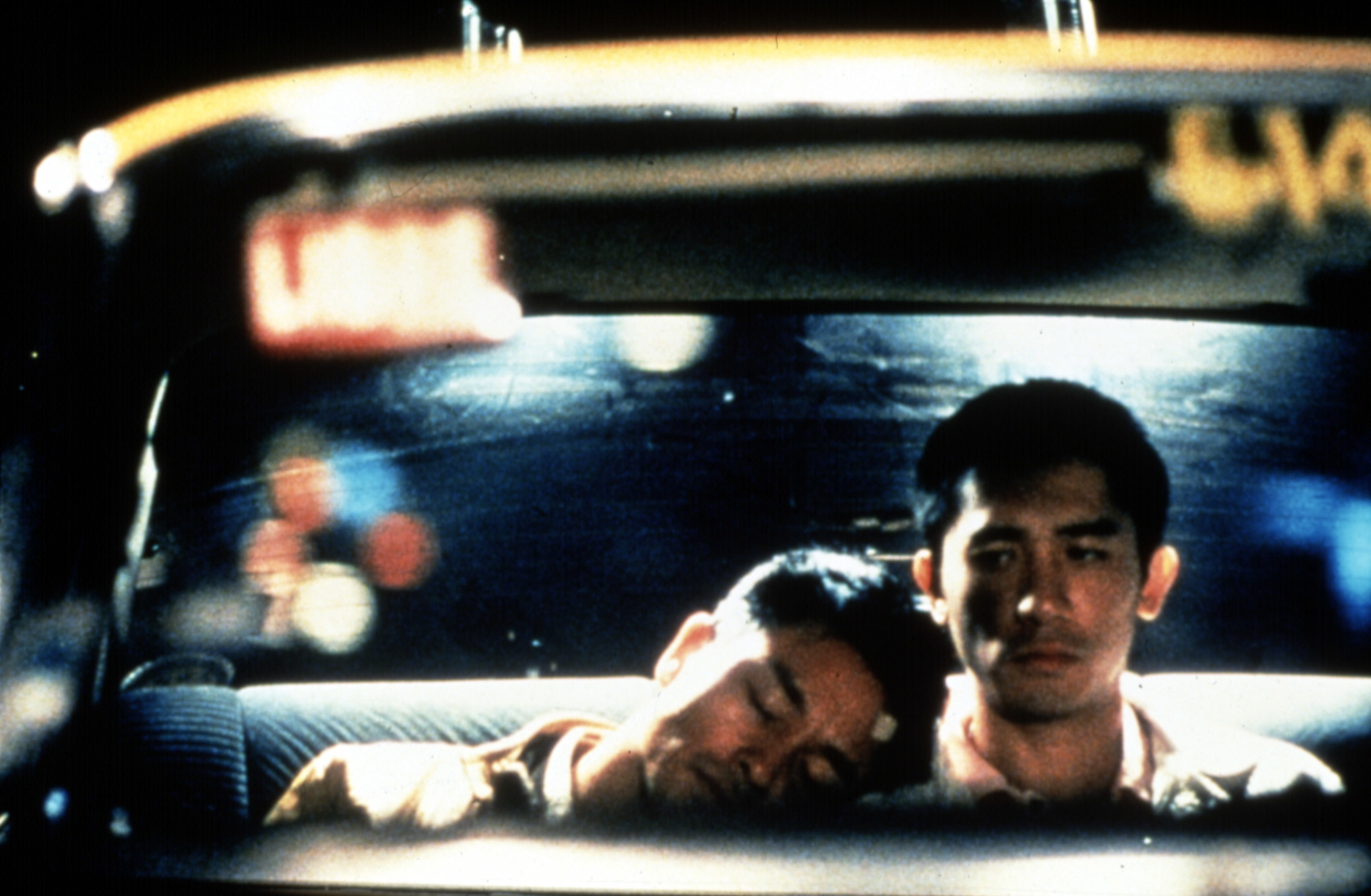 image of a man resting his head on another man in a car