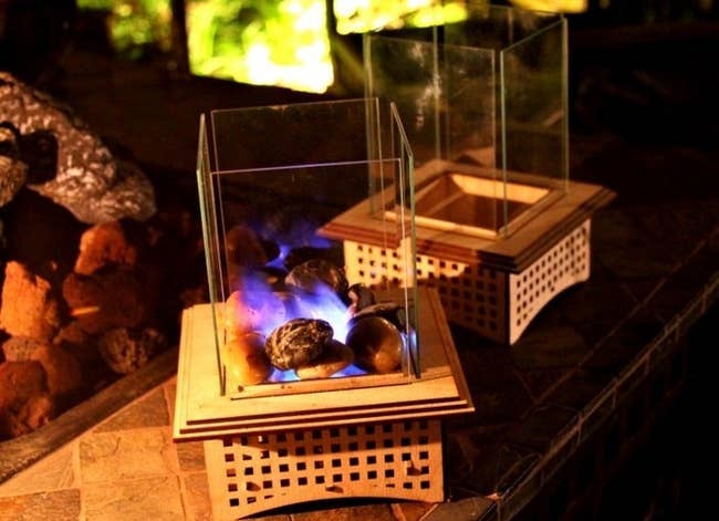 A mini tabletop glass fireplace burning