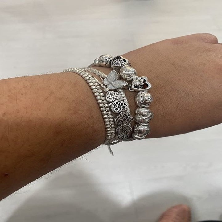Reviewer wearing the charm-filled bracelet