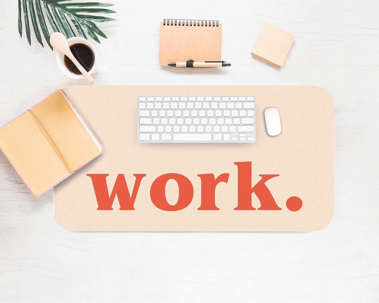 lifestyle image of beige desk pad that says, &quot;work.&quot;