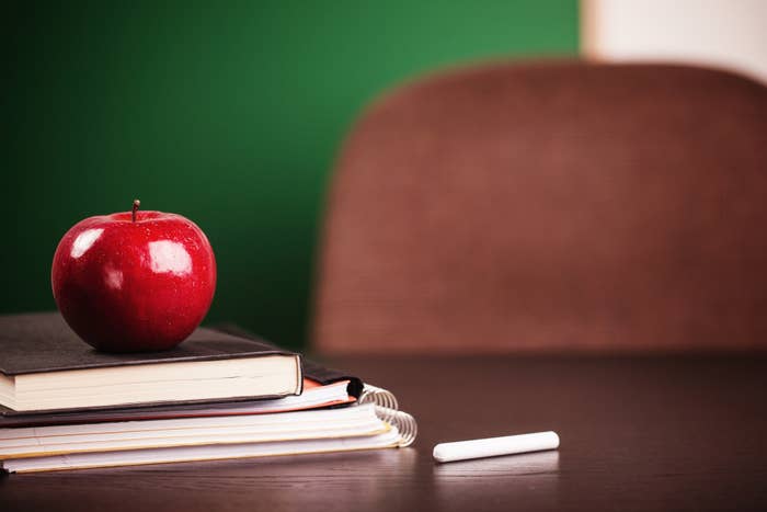 desk with books and an apple on top of it