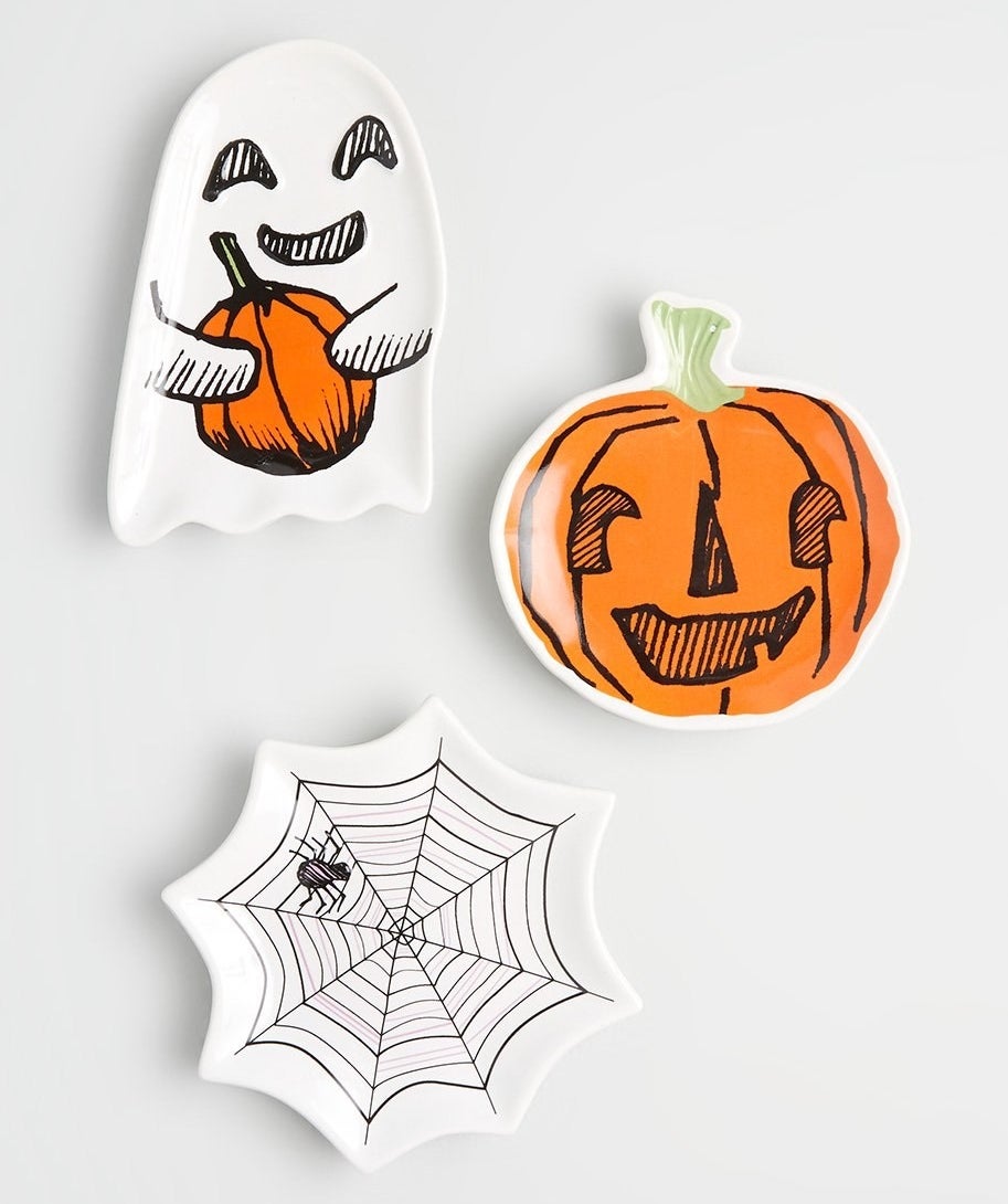 Three Halloween-themed ceramic dishes: A ghost, a spider web, and a jack-o-lantern
