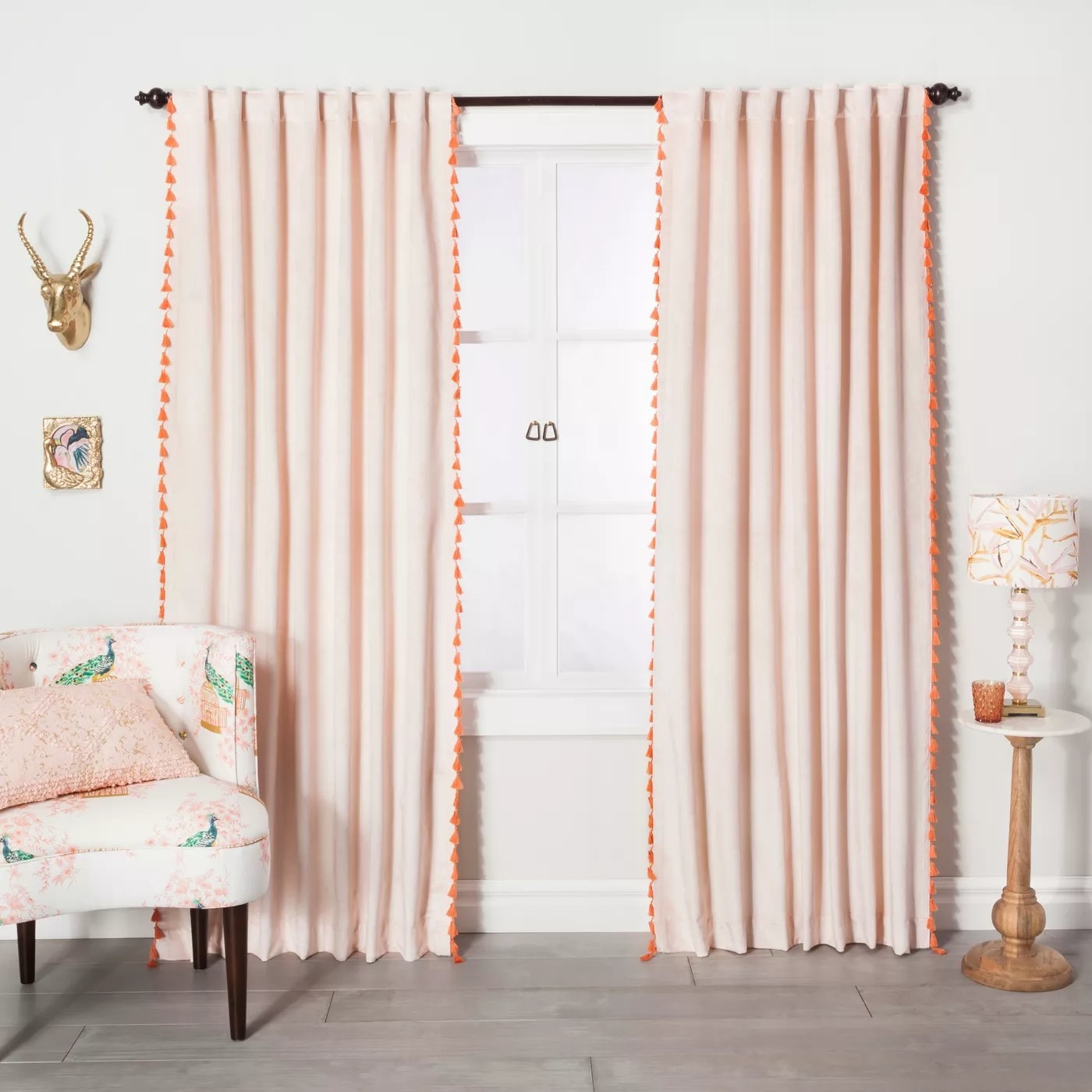 the velvet curtains with orange tassels hanging in a living room