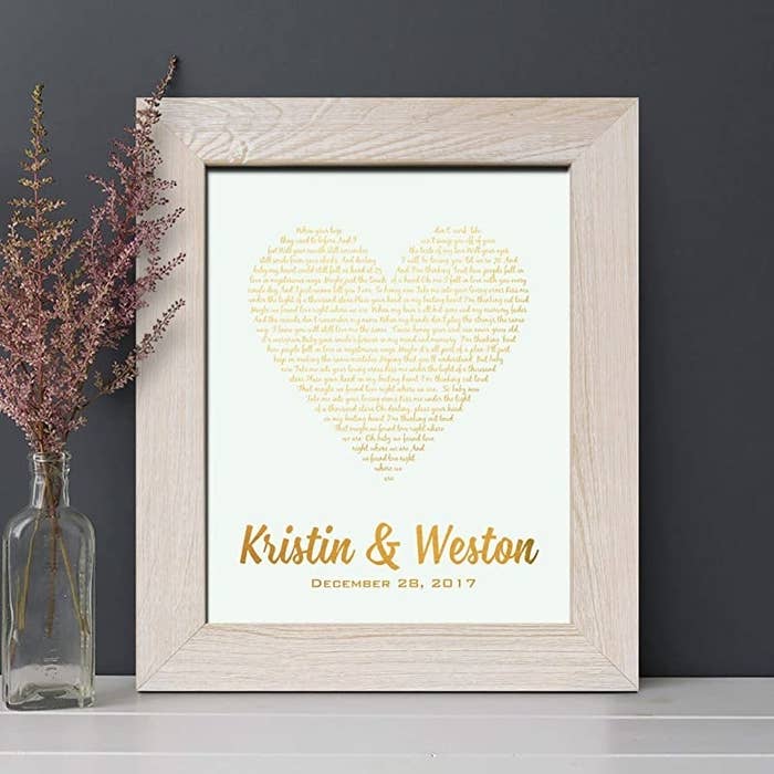 A product photo of song lyrics written in the shape of a heart with the couple's name written below and the date