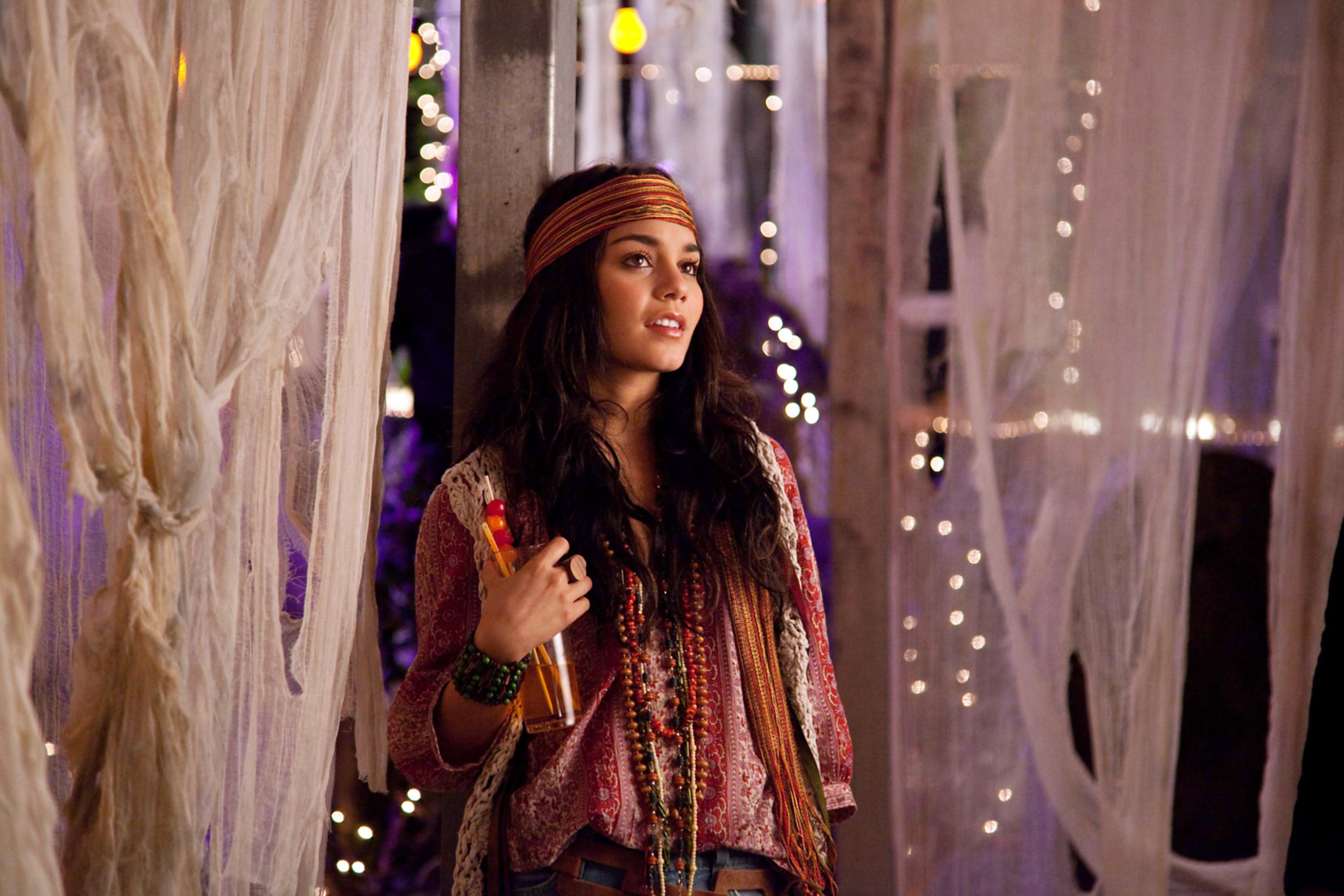Lindy in a hippie costume with a scarf, beads, and vests