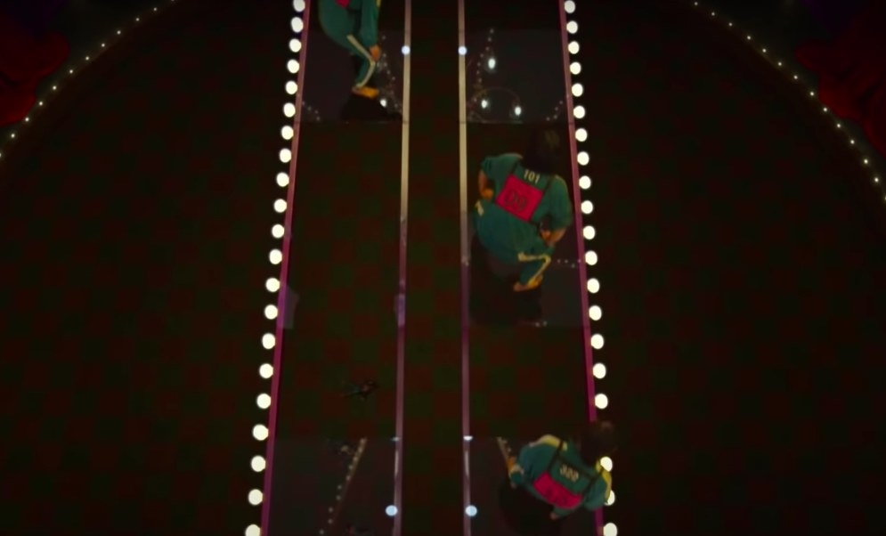 Players are seen from above on a glass stepping stone bridge