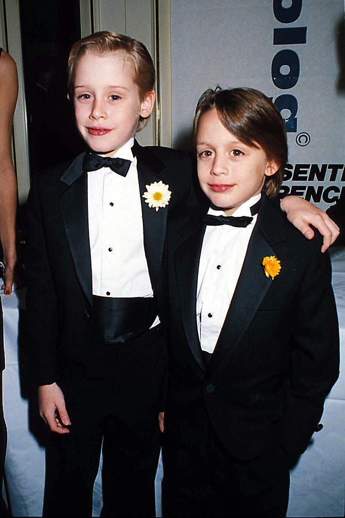 Macaulay Culkin and Kieran Culkin (R) as children pose for photographers at an event