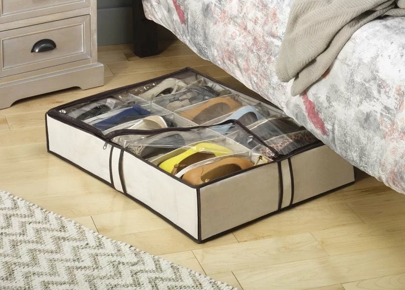A canvas shoe storage container under a bed