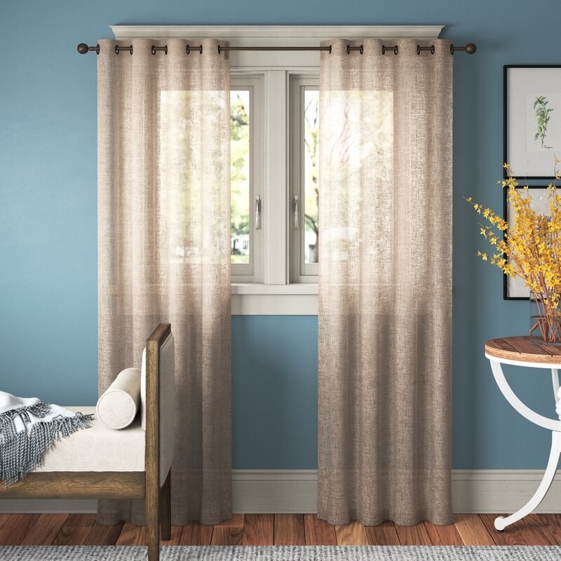 Tan curtains in home with blue walls