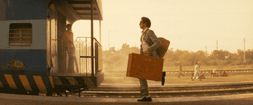 Man with suitcase runs to catch a train
