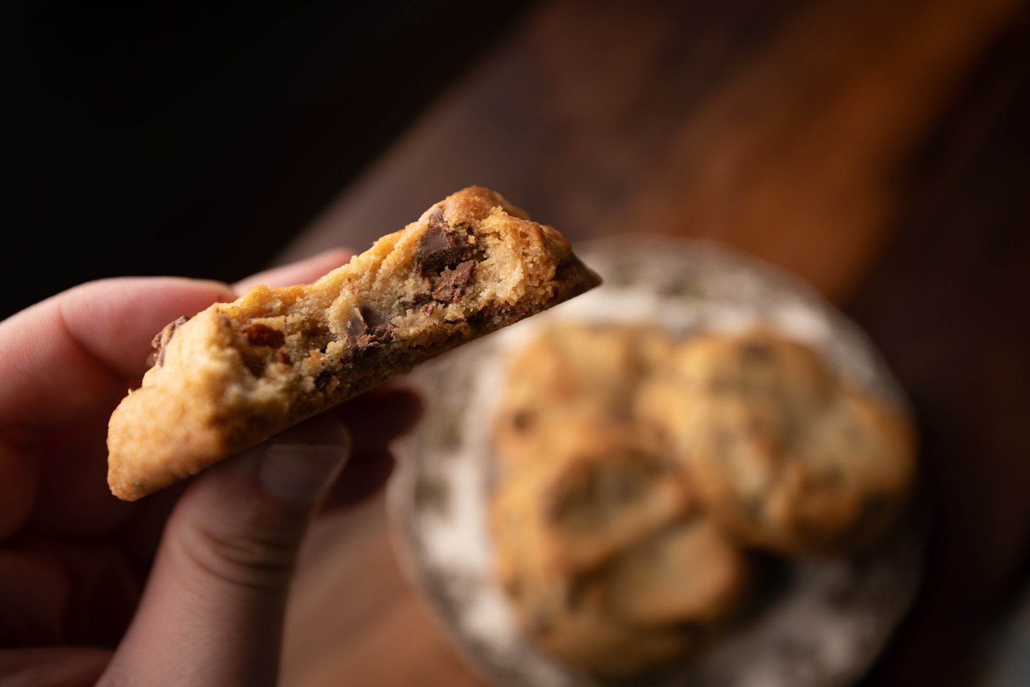 A chocolate chip cookie with a bite taken out of it.
