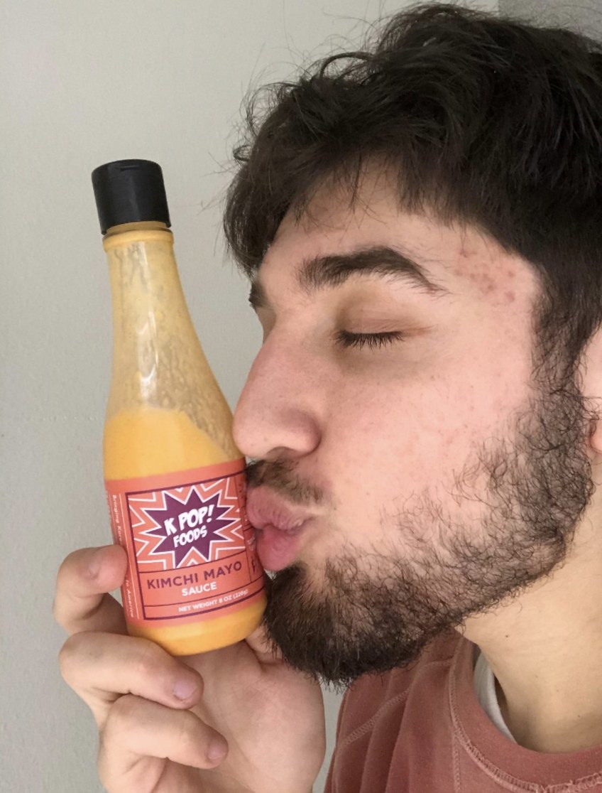 Man kissing kimchi mayo sauce bottle