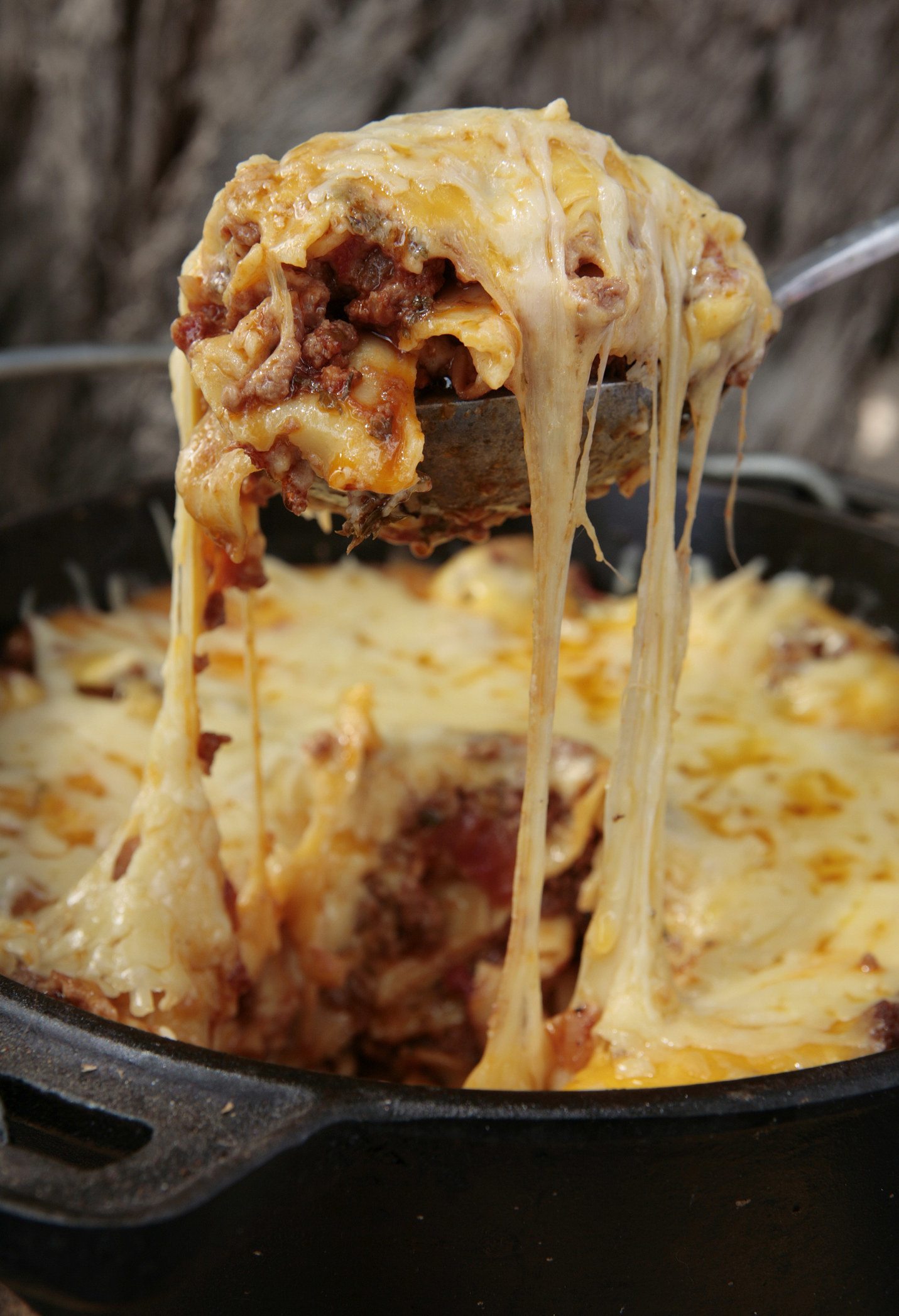 A slice of lasagna in a skillet.