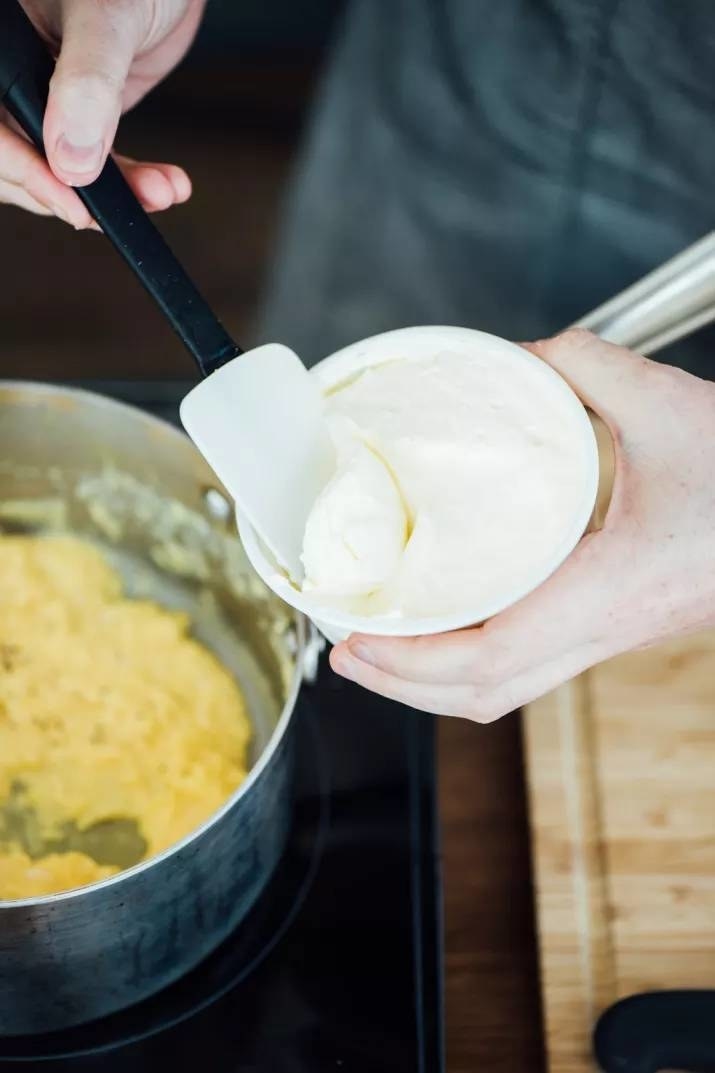 Sour cream going into scrambled eggs.