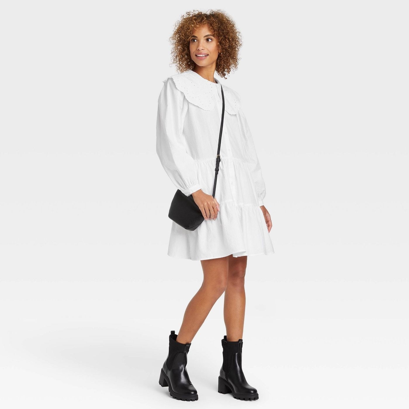model in white tiered above the knee long sleeve dress with boots